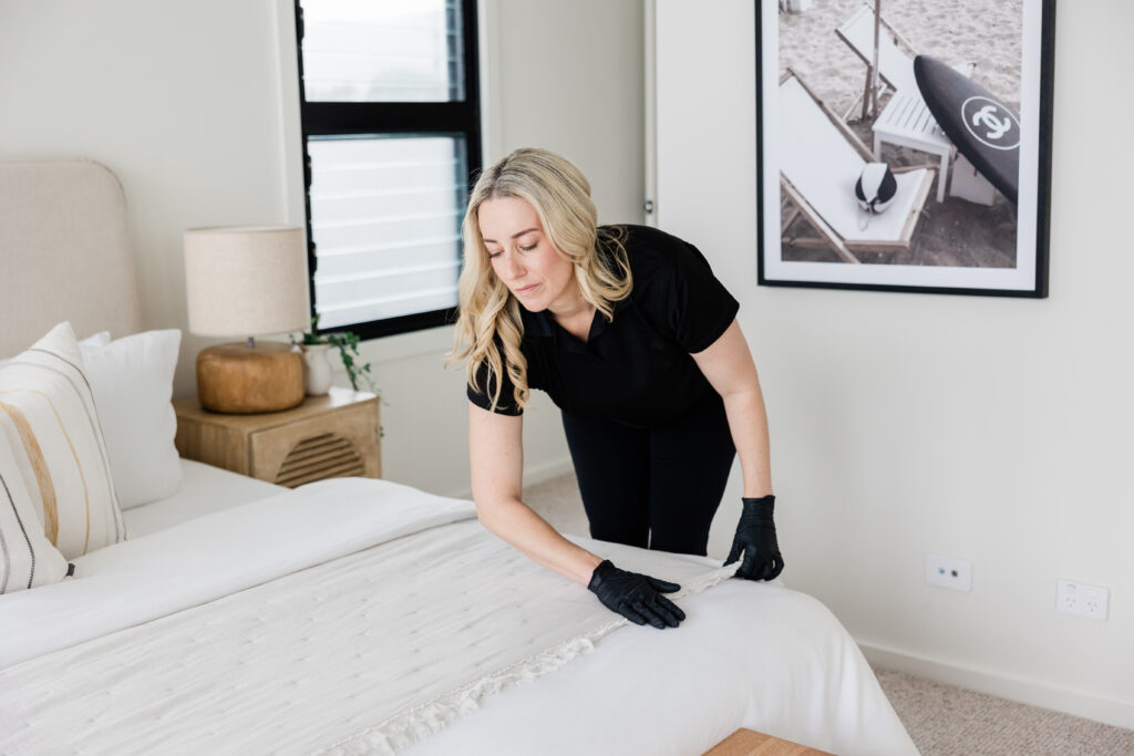 Professional residential cleaner making a bed in a Central Coast home